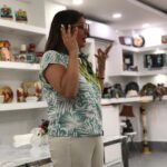 Vivianne Verschae expresándose con entusiasmo durante un taller, en un espacio decorado con arte y manualidades.